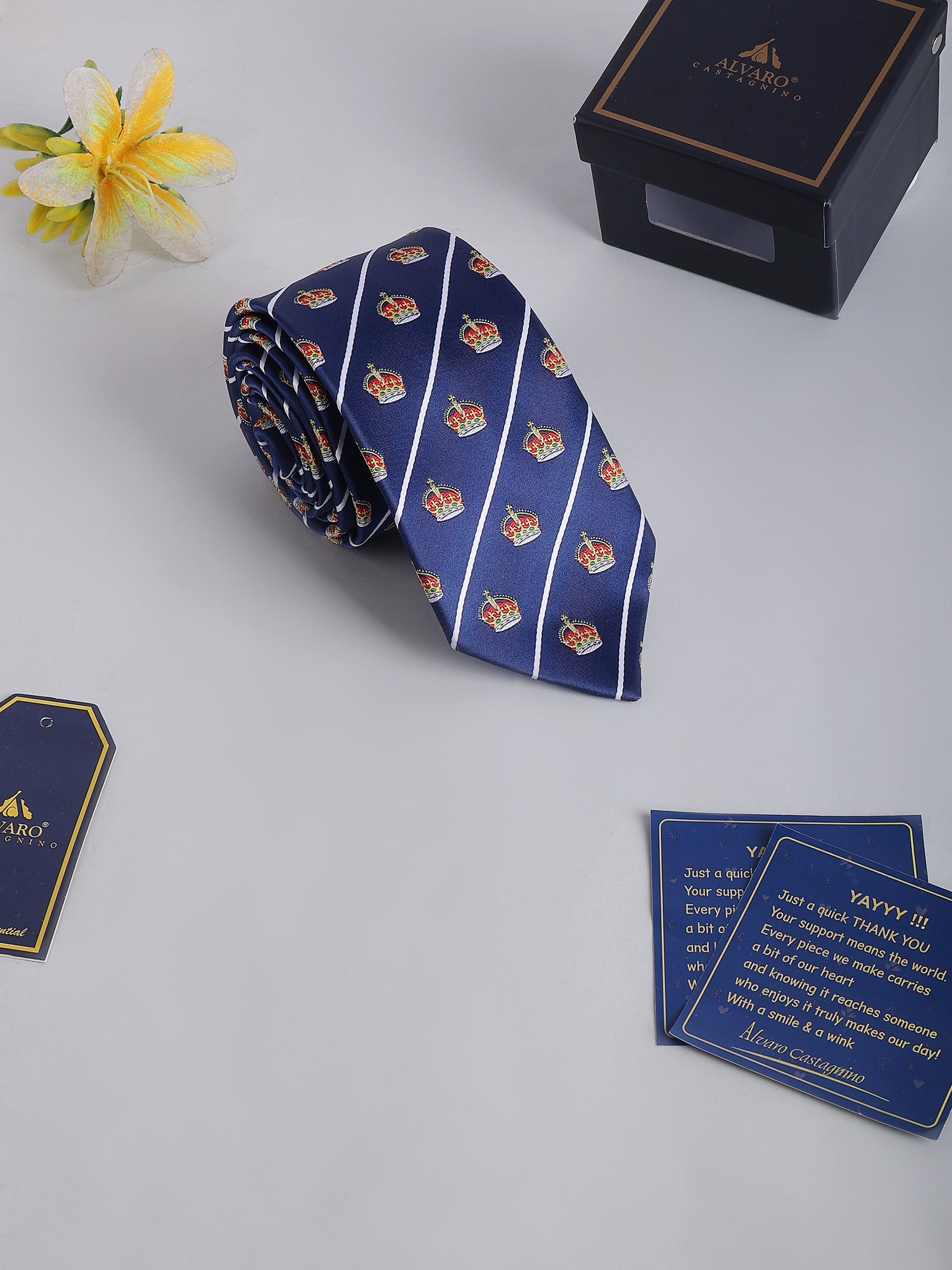 Blue striped tie with logo, packaging box, and tag on a light gray background