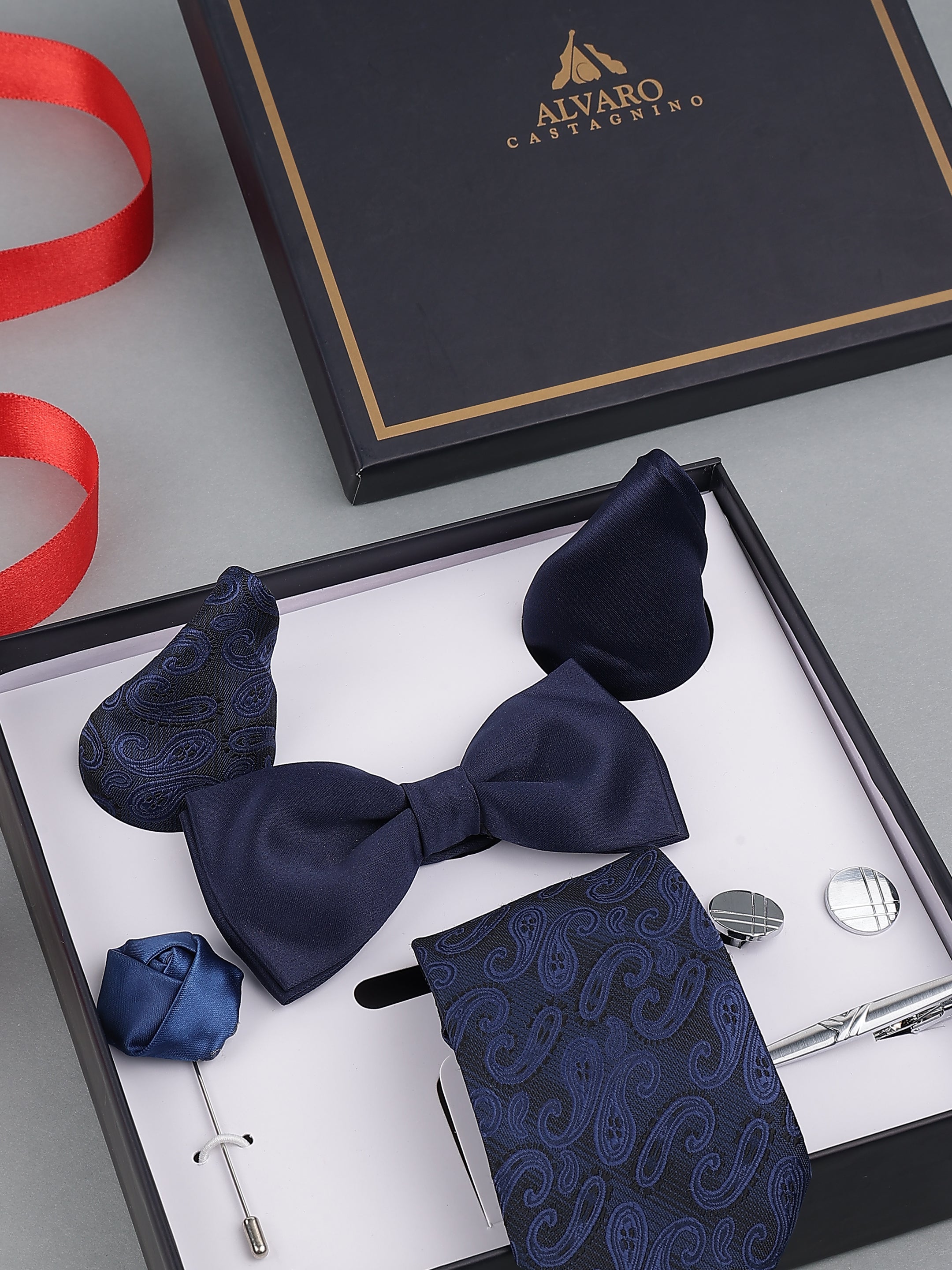 Navy blue bow tie, pocket square, and accessories in a gift box with Alvaro Castagnino branding.