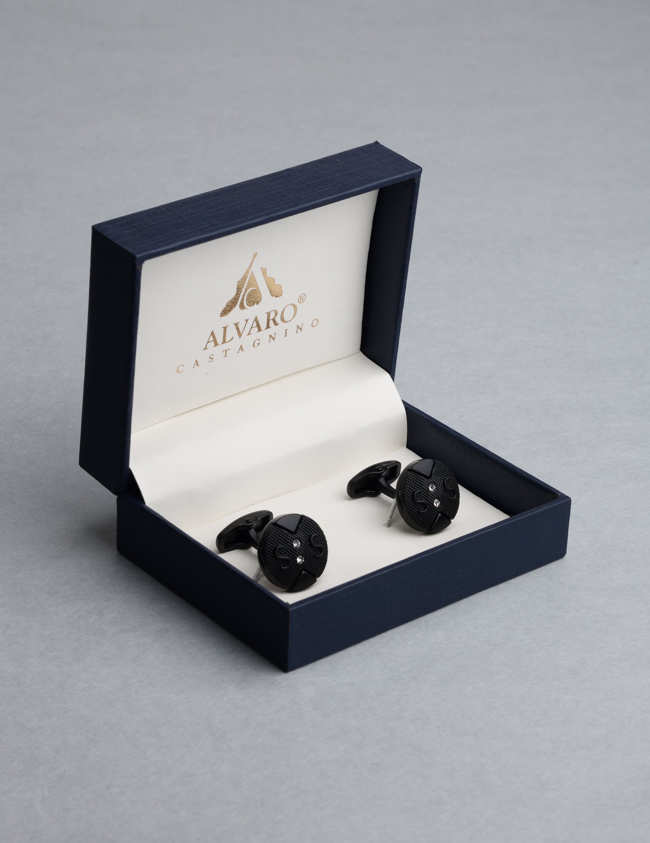 Black cufflinks in an open Alvaro Castaner box on a gray background