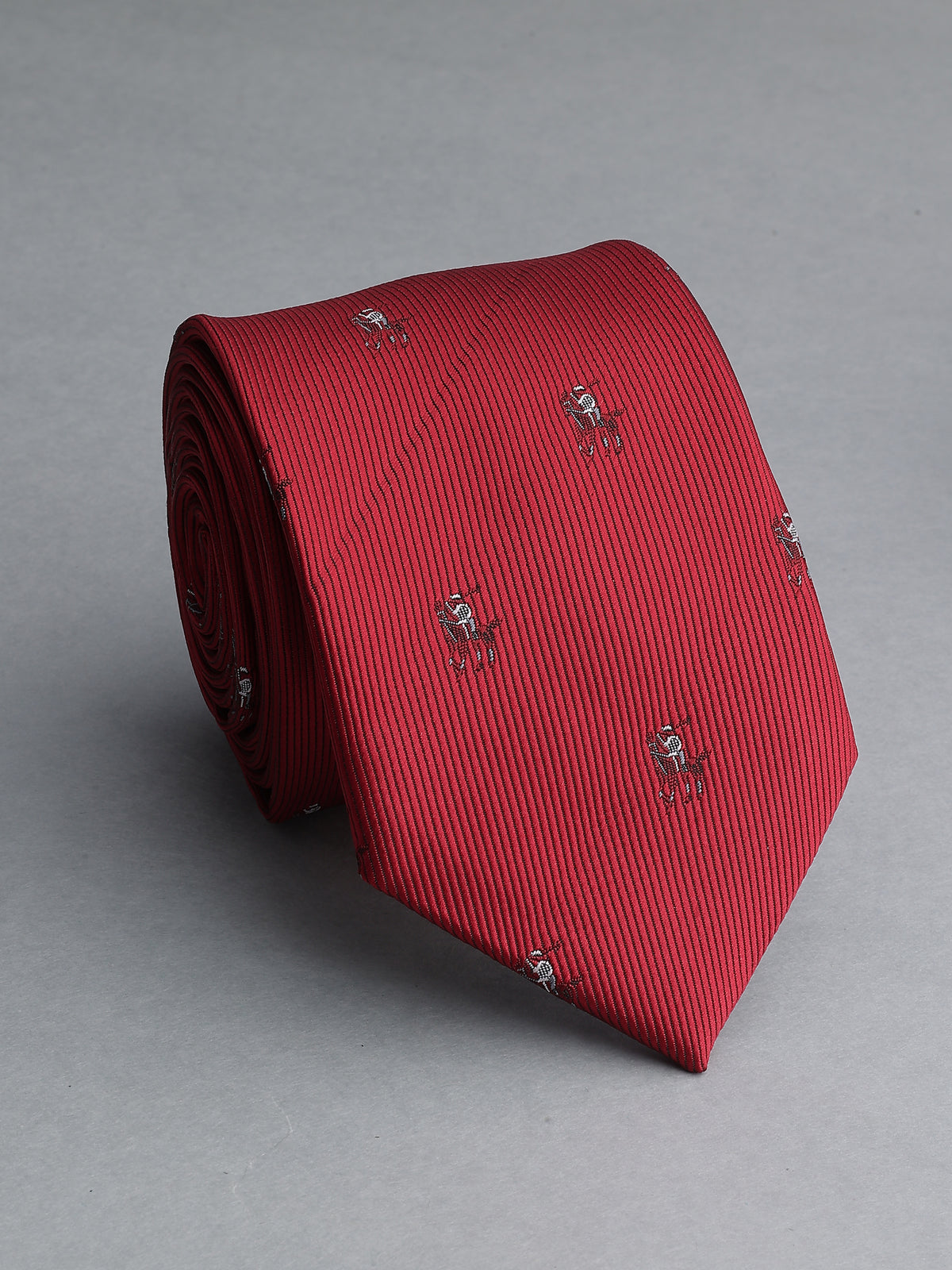 A rolled red necktie with a fine vertical stripe pattern and small embroidered crest motifs, displayed on a neutral gray background.